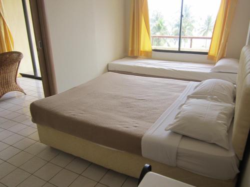 a bed sitting in a room with a window at Paradise Lagoon Apartment in Port Dickson