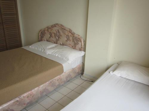 a small bedroom with two beds in it at Paradise Lagoon Apartment in Port Dickson