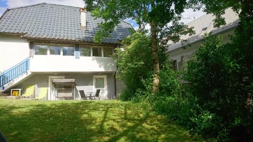 a white house with a table and chairs in the yard at Apartments Rupnik in Bovec