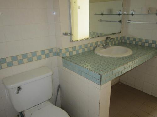 a bathroom with a sink and a toilet and a mirror at Paradise Lagoon Apartment in Port Dickson