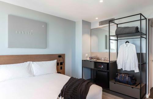 a bedroom with a white bed and a mirror at Citadines Connect Sydney Airport in Sydney