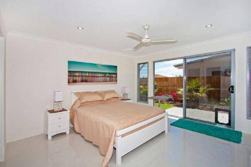 a bedroom with a bed and a large window at Casuarina Beach House by Kingscliff Accommodation in Kingscliff
