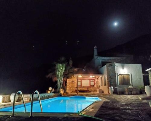 a swimming pool at night with the moon in the background at Sun Holiday House in Pisses