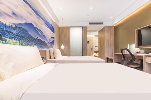 a hotel room with a bed and a tv at Atour Hotel Changxing Central Plaza in Changxing