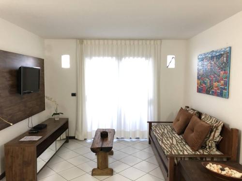 a living room with a couch and a tv at Villa Domenico in Salvador