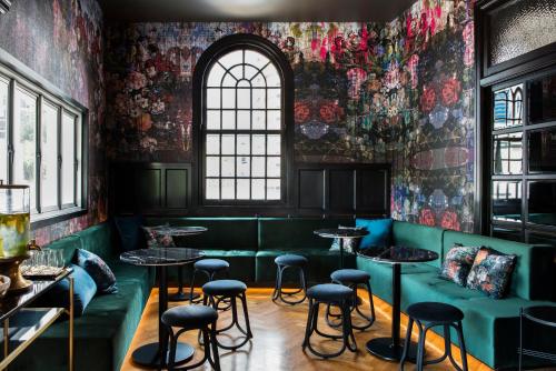 a restaurant with green booths and tables and a window at The Inchcolm by Ode Hotels in Brisbane