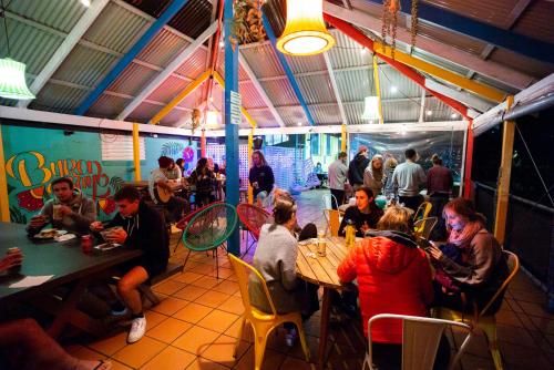 a group of people sitting at tables in a restaurant at YHA Cape Byron, Byron Bay in Byron Bay