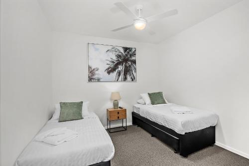 a bedroom with two beds and a ceiling fan at Rockpool 2 Sawtell Beach - Just steps to Restaurants and 2 min Stroll to Beach! in Sawtell