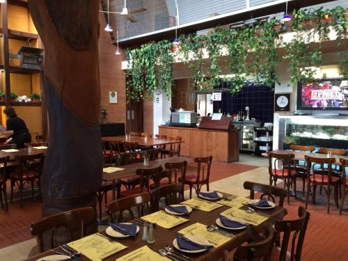 a dining room with tables and chairs and plants at The Pemberton Hotel in Pemberton