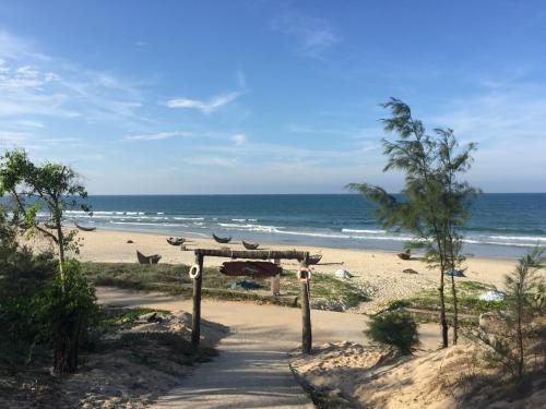 a path to the beach with the ocean in the background at Homstay Lac Long Quan in Tam Kỳ
