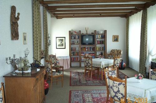 sala de estar con mesa, sillas y TV en Haus-Maria en Bad Salzschlirf