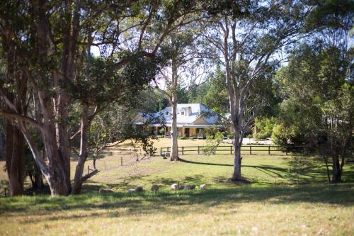 a house in the middle of a field with trees at The Willows at Kurrajong in Kurrajong