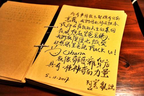 an open book with writing on it on a table at Taitung Ohana Sky Hostel in Taitung City