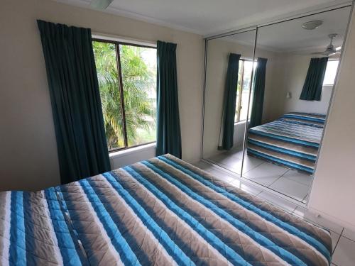 1 dormitorio con 1 cama grande y espejo en Halliday Bay Resort, en Seaforth