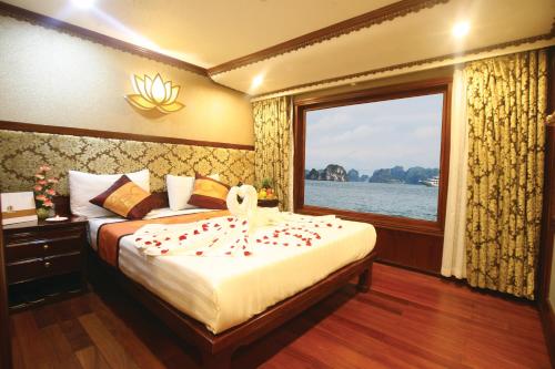a bedroom with a large bed with a window at Oriental Sails Cruise in Ha Long