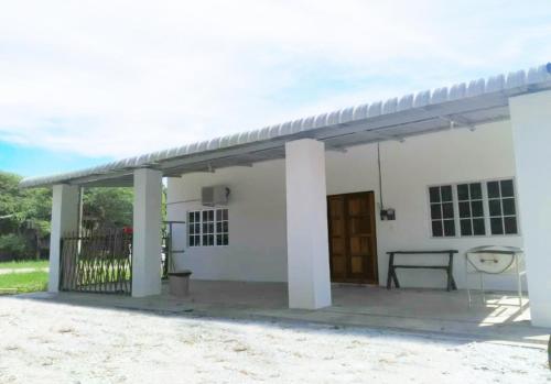 a small white house with a porch at Homestay Langkawi Airport in Kampung Padang Masirat