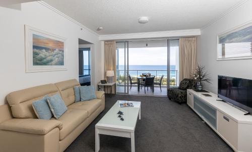 uma sala de estar com um sofá e uma televisão em Ocean Pacific Resort - Official em Gold Coast