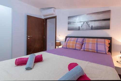 a bedroom with a large bed with pink towels on it at Apartments Dijana in Zadar