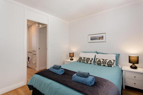 a bedroom with a bed with blue towels on it at Ocean Breeze Apartment in Fremantle