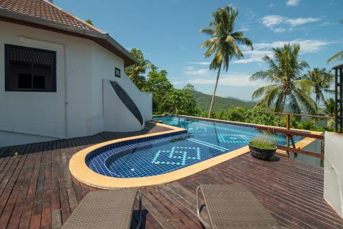 una piscina en una terraza junto a una casa en Samui Paradise Village en Nathon