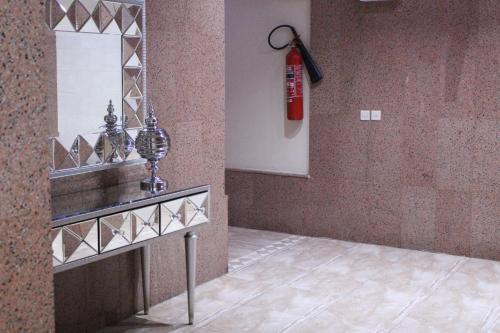 a living room with a fire extinguisher on the wall at Zaer Al Fakhama Hotel Apartments in Tabuk