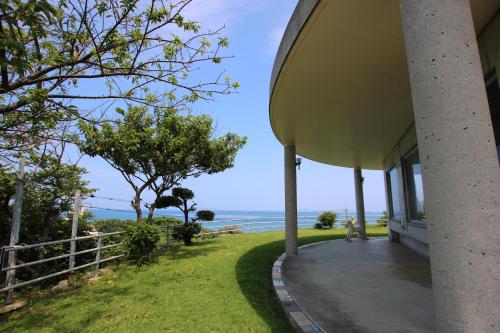 a view of the ocean from the porch of a house at Minshuku Tantawan -SEVEN Hotels and Resorts- in Motobu