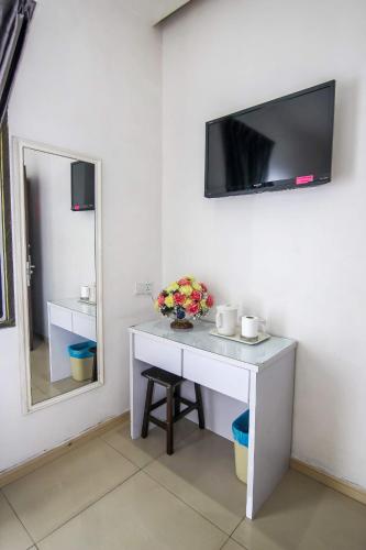a room with a desk and a tv on the wall at Rose Cottage Hotel Taman Impian Senai in Johor Bahru