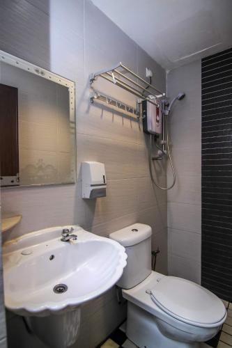 a bathroom with a white toilet and a sink at Rose Cottage Hotel Taman Impian Senai in Johor Bahru