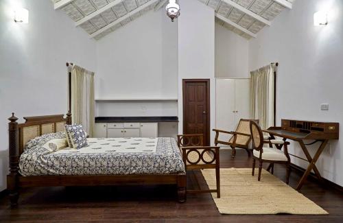 a bedroom with a bed and a table and chairs at Hirvate Estate / Crawford House in Hassan