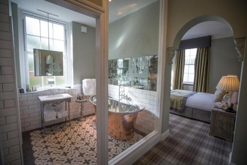 a large bathroom with a tub and a bed at Bowburn Hall Hotel in Durham