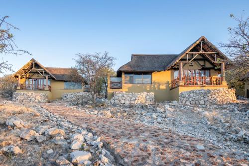 a house on a hill with a stone driveway at Epacha Game Lodge & Spa in Okaukuejo