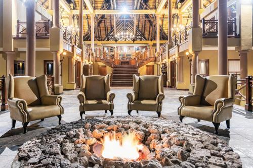 a lobby with chairs and a fire pit at Epacha Game Lodge & Spa in Okaukuejo
