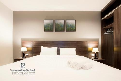 a bedroom with a white bed with two towels on it at Feungfah Litz in Phetchabun