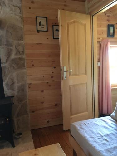 a bedroom with a door and a stone wall at Cozy Cabin in Žabljak