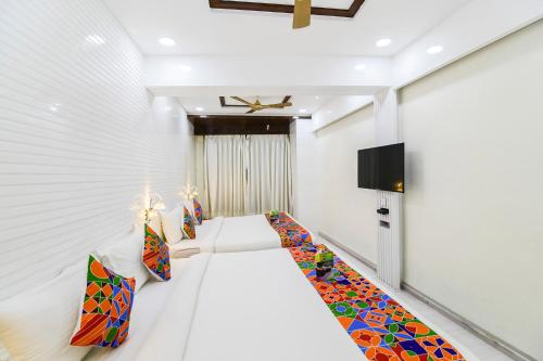 a room with a bed with colorful pillows at Hotel Om Stay Well in Indore
