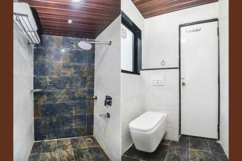 a bathroom with a toilet and a walk in shower at Hotel Om Stay Well in Indore