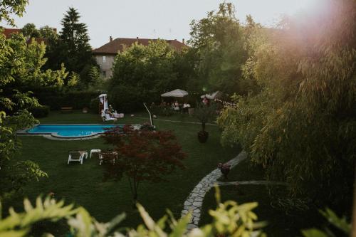 un patio trasero con piscina y jardín en Hotel La Residenza, en Timisoara