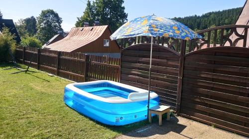 a blue boat sitting on the grass next to an umbrella at Chaloupka Albrechtice in Albrechtice v Jizerských horách