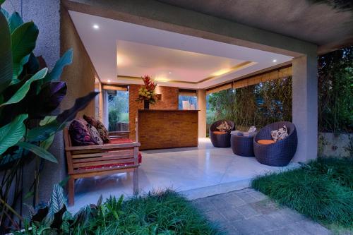 a patio with chairs and a table and a large window at Villa Tegal Tis Ubud in Payangan