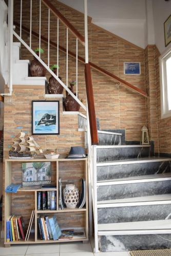 a staircase in a house with a book shelf at Oceanis Hotel in Tyros