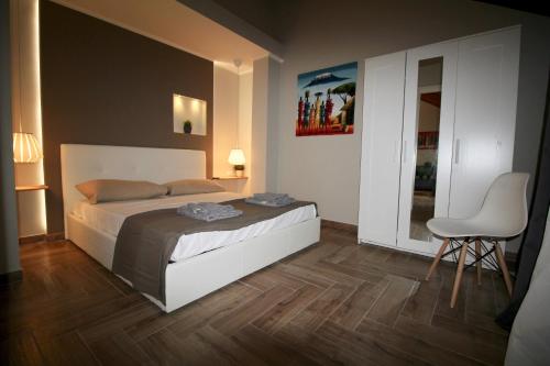 a bedroom with a bed and a table and a chair at Katana suites beach in Agnone Bagni