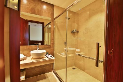 a bathroom with a sink and a glass shower at Gokulam Park Coimbatore in Coimbatore