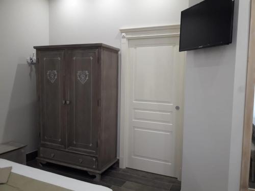 a bedroom with a wooden cabinet and a flat screen tv at veronica's b&b in Lesina
