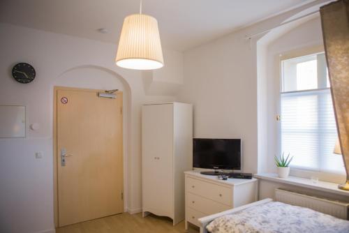 a bedroom with a door and a television and a window at ApartOne Palais-Apartments in Bautzen