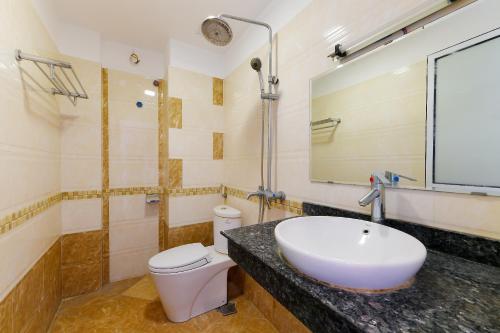 y baño con lavabo, aseo y espejo. en TITANIC HOTEL, en Hanói