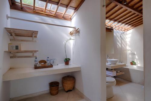 a bathroom with a toilet and a sink at Villa Tegal Tis Ubud - CHSE Certified in Payangan