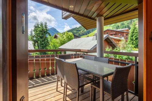 un patio avec une table et des chaises sur un balcon dans l'établissement LA PLOCHE 6, à Morzine