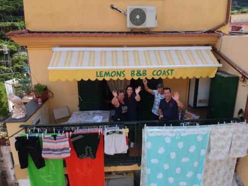 Un groupe de personnes debout sous un auvent avec des vêtements suspendus dans l'établissement B&B Lemons Coast, à Cetara