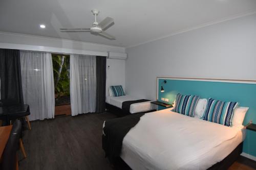 a hotel room with a large bed and a television at Ballina Homestead Motel in Ballina