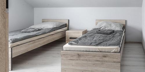 two beds in a room with a bed frame at 7a KLIMA in Ślesin